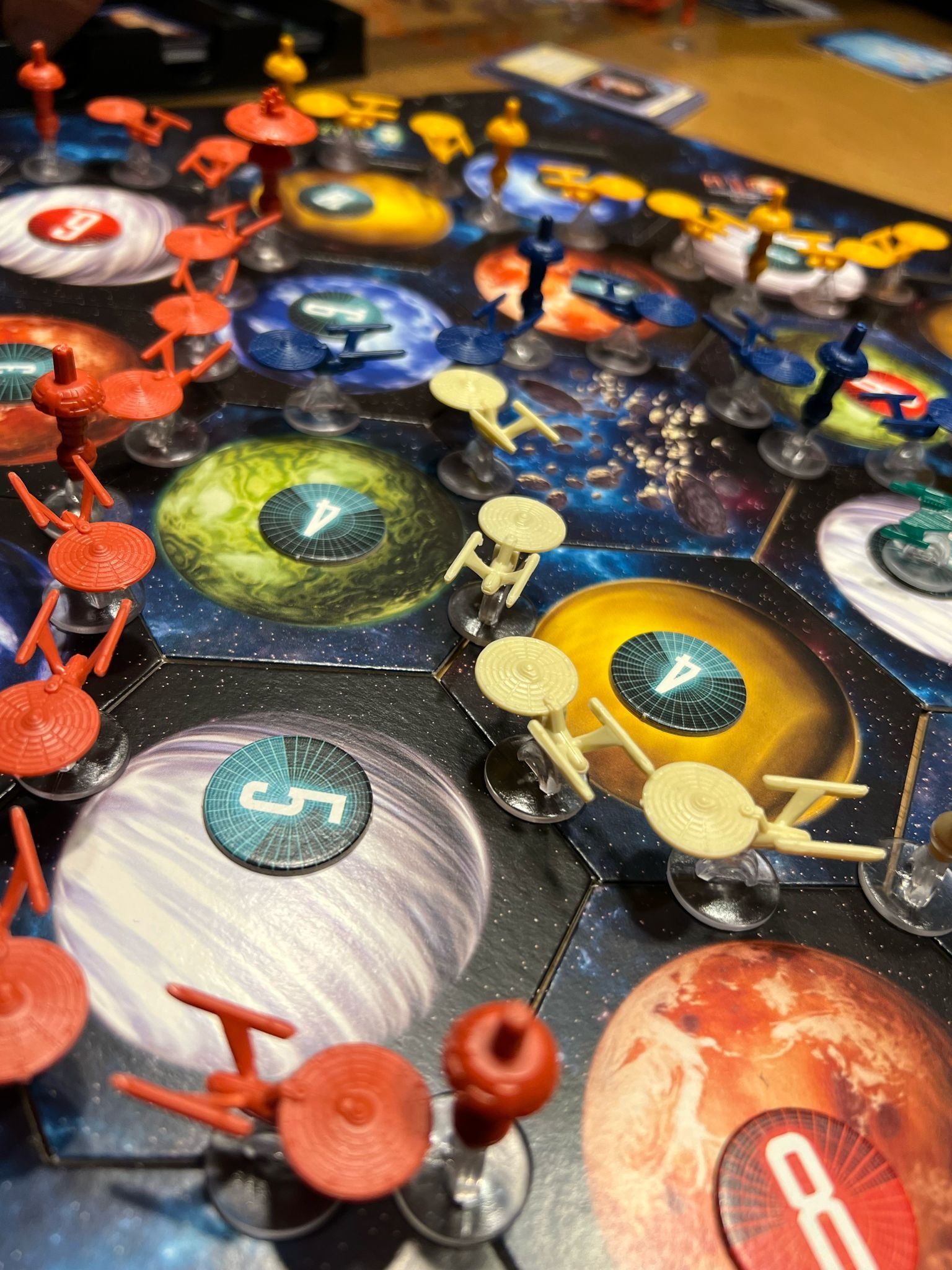 CATAN Spielbrett im All mit roten, weißen, blauen und gelben Raumschiff Enterprise Miniaturen